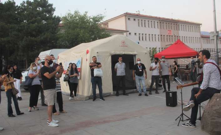 Erzincan’da kurulan mobil aşı çadırının önünde vatandaşlar canlı müzik eşliğinde