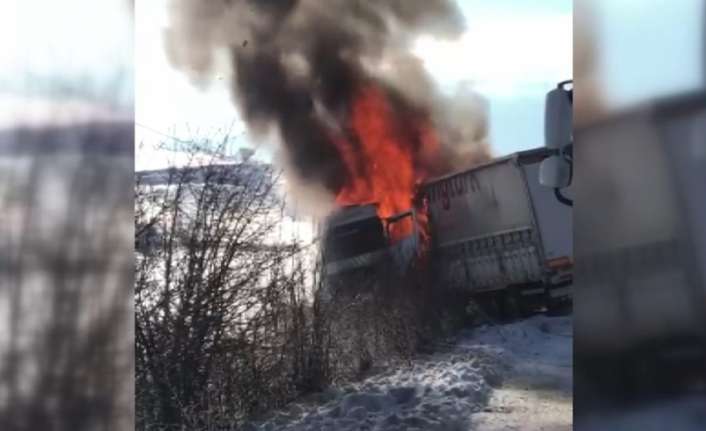Karlı ve buzlu zeminde kayarak yoldan çıkan tır alev alev