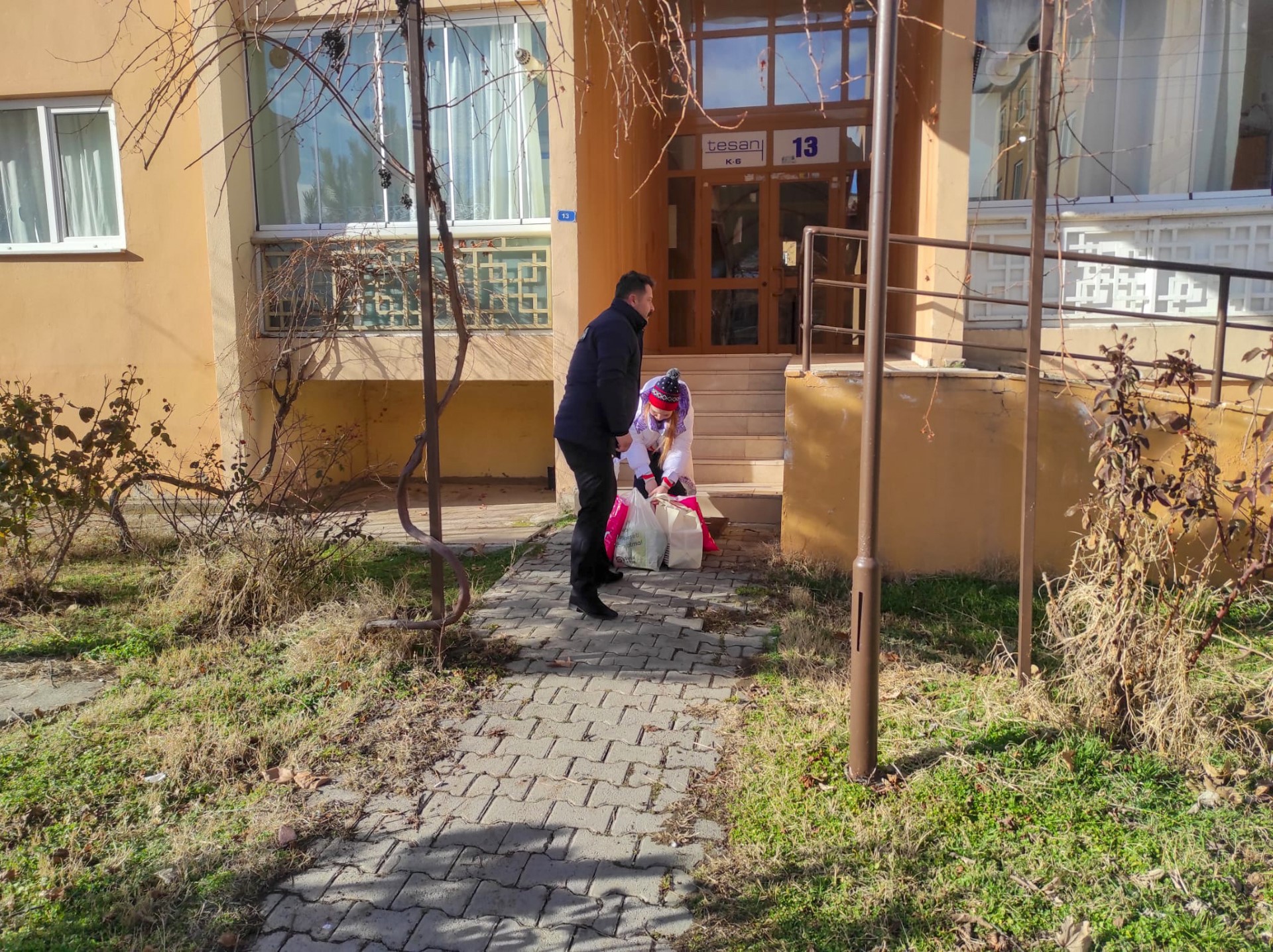 Erzincan Belediyesi Zabıta personelleri elindeki poşetlerle yürümekte zorluk çeken yaşlı